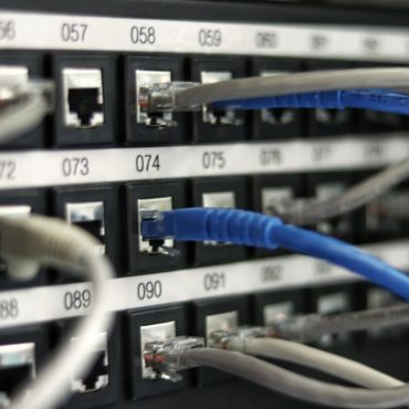Network patch panel with rows of colored cables, the physical infrastructure behind a website