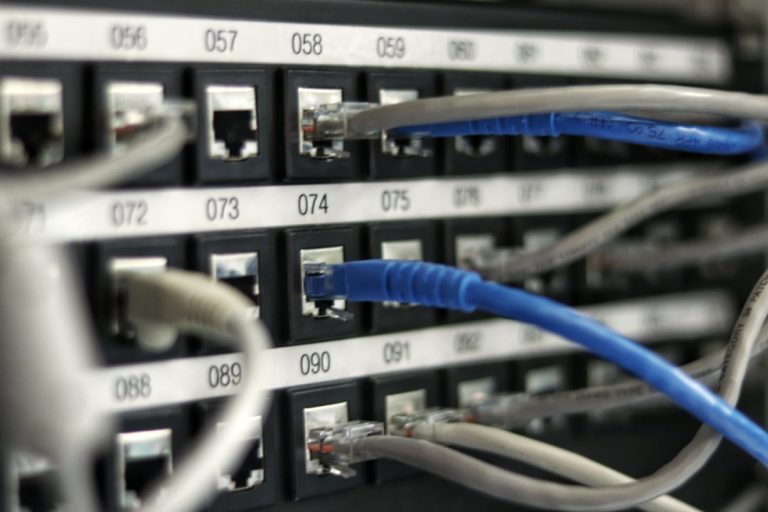 Network patch panel with rows of colored cables, the physical infrastructure behind a website