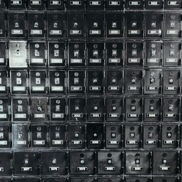 A grid of old metal post office boxes with brass doors
