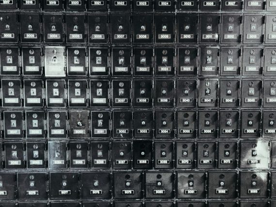 A grid of old metal post office boxes with brass doors