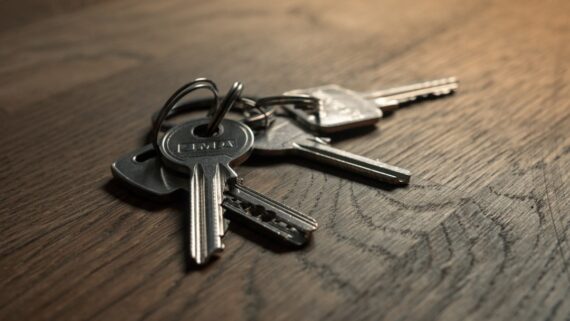 A set of keys on a wooden desk, representing ownership of and access to a business website