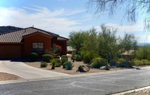 Adobe-style home with desert landscaping and a driveway, the kind of property listing a Santa Fe brokerage displays through an IDX feed