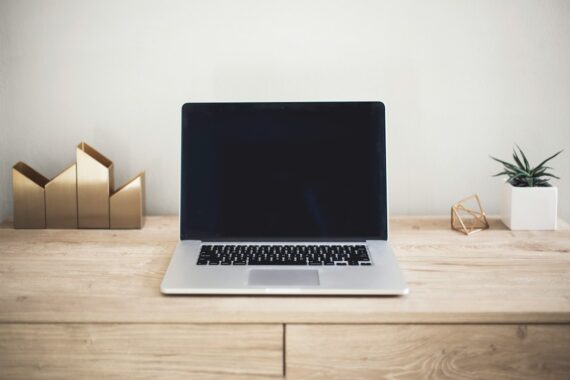 Open laptop on a light wood desk, representing a small business checking how it appears in search and AI answers