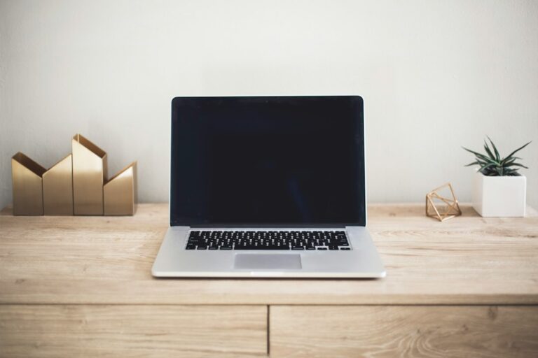 Open laptop on a light wood desk, representing a small business checking how it appears in search and AI answers
