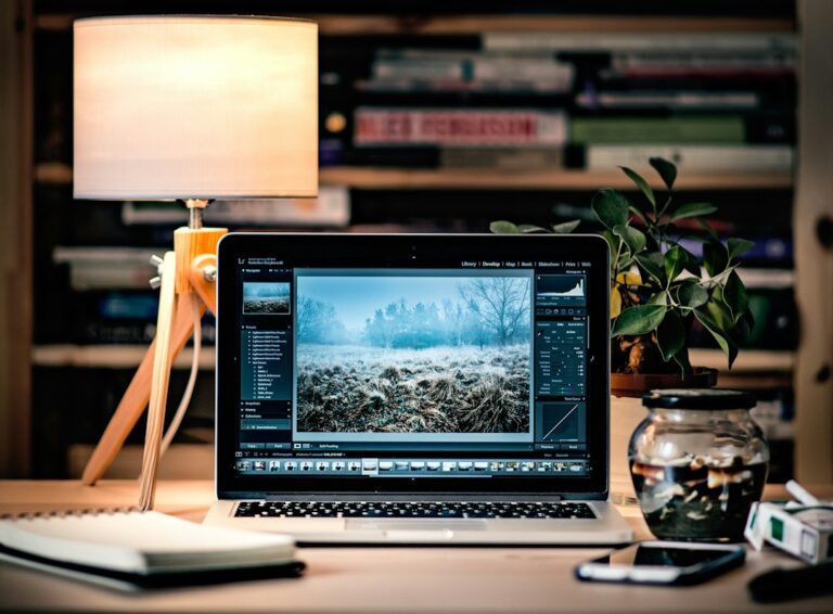 Laptop open to a grid of photographs while editing image details on a website