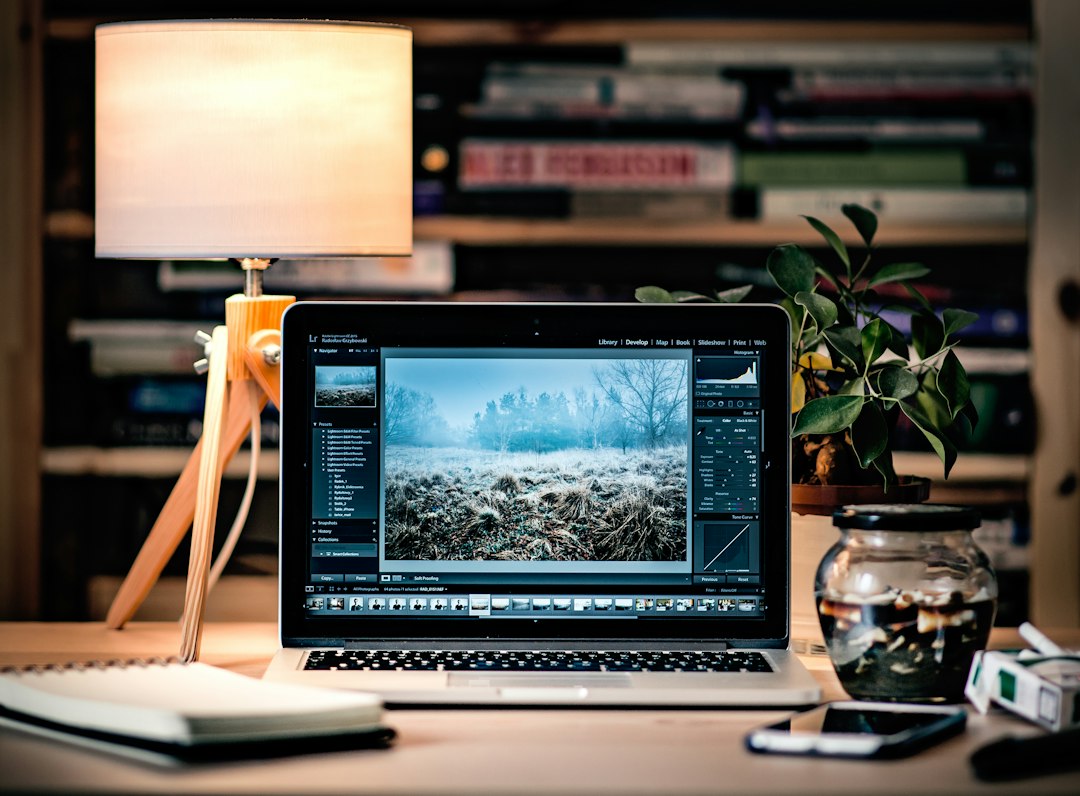 Laptop open to a grid of photographs while editing image details on a website